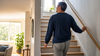 Stroke recovery featured image showing a person walking up stairs near a railing in warm natural light
